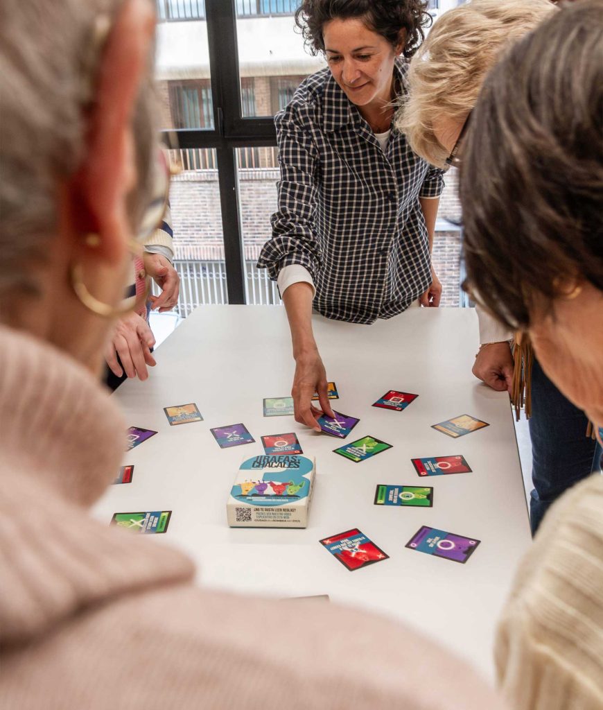 Personas mirando una mesa donde están las cartas de Jirafas y Chacales 3